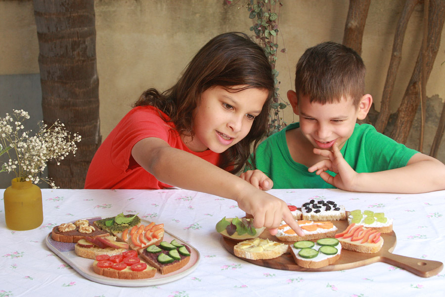איך לגרום לילדים לאכול מגוון | ילד מול מגשי סנדוויצ׳ים | סנדוויץ׳ לבית ספר | מסיבת סנדוויצ׳ים לילדים | הבלוג של נעמה מגשימת מתנות | naamasimanim.co.il